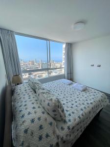 a bedroom with a bed and a large window at Nuevo alojamiento en el corazón Iquique in Iquique