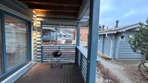uma varanda de uma casa com uma cadeira em Laakson Helmi 2 ,separate sauna, fireplace, lake em Himos