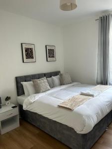 a bedroom with a large bed with white sheets at Mideyah Stays - 3 Bed Comfy House in Cardiff