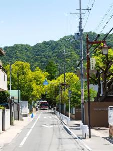 una calle vacía con árboles y una montaña en IIIホーム en Shijonawate