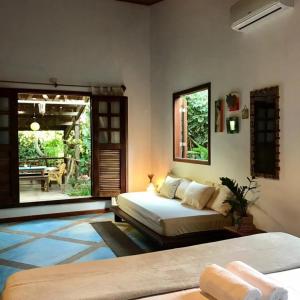 a bedroom with two beds and a patio at Dellacasa in Jericoacoara +45 photos