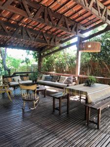 a wooden deck with a bench and a table and chairs at Dellacasa in Jericoacoara