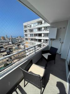 a balcony with two chairs and a table on a building at Nuevo alojamiento en el corazón Iquique in Iquique