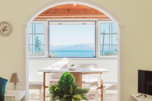 a room with a table and a large window at Achilleion Holiday Home in Achílleion +25 photos