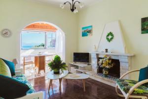 a living room with a fireplace and a tv at Achilleion Holiday Home in Achílleion