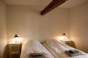 two beds in a bedroom with two lights on them at The Mill House - Saeby Watermill in Sæby