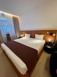 a bedroom with a large bed and a window at Golden Lisbon Hotel in Lisbon