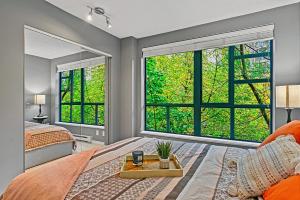 a bedroom with a bed and two large windows at Stunning 3 Bed Duplex in Yaletown w Fireplace in Vancouver