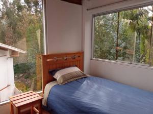 ein Schlafzimmer mit einem Bett und einem großen Fenster in der Unterkunft Chullpa's House in Urubamba