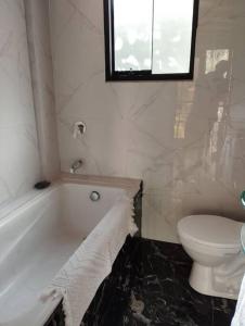La salle de bains est pourvue d'une baignoire blanche et de toilettes. dans l'établissement Chullpa's House, à Urubamba