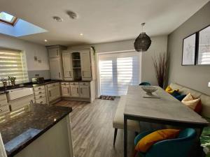 a kitchen with a table and a living room at Allt Lwyd - Peaceful & Tranquil Setting in Bangor