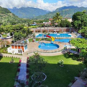 una gran piscina con un tobogán en un parque en Hotel El Tirol, en San Ramón