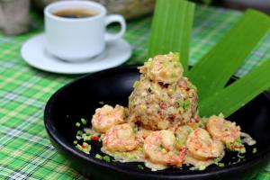 a plate of shrimp on a table with a cup of coffee at Nativa Bambu Ecolodge in Montañita