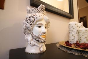 um vaso branco sentado numa mesa ao lado de um bolo em Casa 4 Archi em Lentini