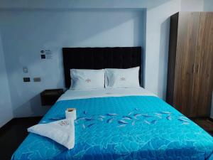 a bedroom with a bed with a blue comforter with fishes on it at Hotel Grand Paradise Marcona in San Juan