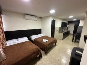 um quarto de hotel com duas camas e uma cozinha em Residencia Terreros em Guayaquil