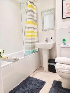 y baño con lavabo, bañera y aseo. en Impeccable 2-Bed House in Coventry en Coventry