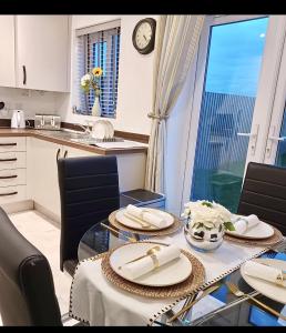 a dining room with a table with chairs and a clock at Impeccable 2-Bed House in Coventry in Coventry