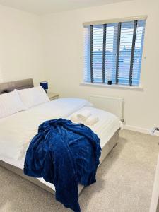コベントリーにあるImpeccable 2-Bed House in Coventryのベッドルーム1室(青い毛布付きのベッド1台付)