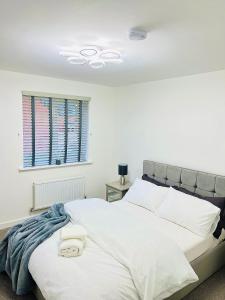 Un dormitorio con una cama blanca con una manta azul. en Impeccable 2-Bed House in Coventry en Coventry