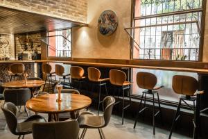 a restaurant with tables and chairs and a window at Hotel Boutique Naura Centro in Oaxaca City