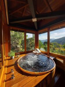 a large tub in a room with windows at Alto de Santa Barbara in São Francisco Xavier