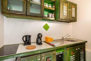 a kitchen with green cabinets and a sink at MAREVIGLIOSO Fronte Mare Sea Front in Magomadas