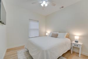 a white bedroom with a bed and a ceiling fan at St Clair Apartment - Walk to River and Boardwalk! in Marysville