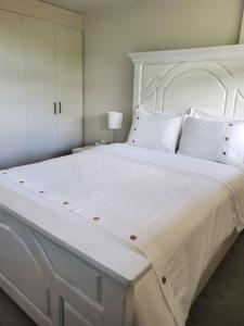 a large white bed with white pillows in a bedroom at Stunning 1 bedroom condo in Calgary with riverview in Calgary