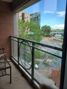 a balcony with a view of a river and a building at Stunning 1 bedroom condo in Calgary with riverview in Calgary