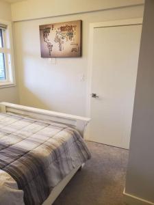 a bedroom with a bed and a door with a picture on the wall at Stunning 1 bedroom condo in Calgary with riverview in Calgary