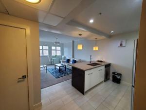 a kitchen and living room with a sink and a table at Stunning 1 bedroom condo in Calgary with riverview in Calgary