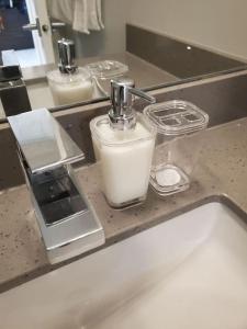 a bathroom counter with a soap dispenser on a sink at Stunning 1 bedroom condo in Calgary with riverview in Calgary