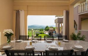 a dining room with a table and a large window at Apartment Marendić in Obrovac Sinjski