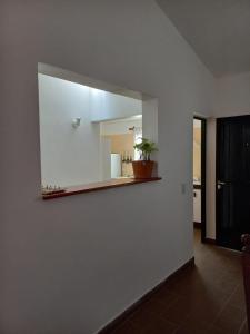 a mirror on a white wall with a plant on a shelf at La Evelia in Salta +14 photos