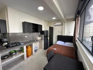 a small room with a bed and a kitchen at Residencia Terreros in Guayaquil