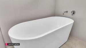 eine weiße Badewanne mit WC im Bad in der Unterkunft Horseshoe Beach House 4 Young Street, Bermagui in Bermagui + 16 Fotos