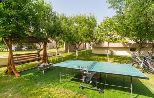 a ping pong table in a park with a picnic shelter at Apartment Marendić in Obrovac Sinjski