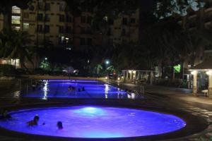 una gran piscina azul con gente por la noche en Chateau Elysee A21 near Airport,bar,Resto, en Manila