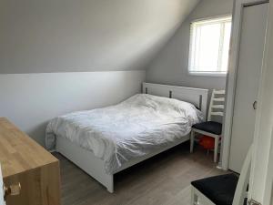 a small bedroom with a white bed and a window at Simply Suite - Cornwall Village in Cornwall