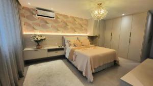 Un dormitorio con una cama grande y una lámpara de araña. en Apartamento em copacabana, en Río de Janeiro