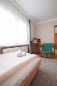 1 dormitorio con 1 cama, 1 silla y 1 ventana en Hotel -Winterfelder Hof, en Winterfeld