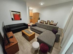 a living room with a couch and a television at Apart Nel in Praia