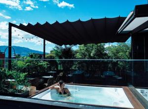 a man in a swimming pool with an umbrella at Nomada Hotel Origen in Medellín