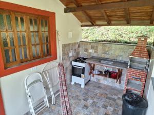 uma cozinha com um fogão e um balcão com cadeiras em Espaço Rural Água da Onça em Guararema