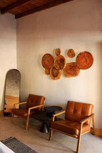ein Zimmer mit 2 Stühlen und Holzplatten an der Wand in der Unterkunft MYA Hotel Boutique in Valle de Guadalupe