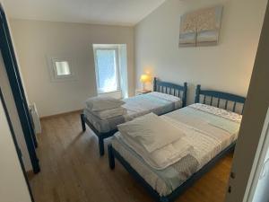 a bedroom with two beds and a window at Gite de Claire Fontaine avec vue sur Monflanquin in Monflanquin