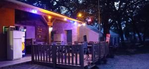 Limogne-en-QuercyCAMPING LE BEL AIR mobil home LE CORNOUILLER 4 personnes的一座晚上在户外设有桌椅的建筑