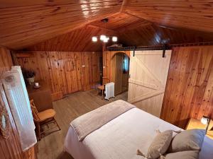 sypialnia z łóżkiem i drewnianym sufitem w obiekcie Finca del Hórreo 