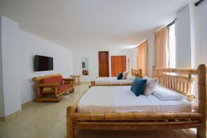 1 dormitorio con 2 camas y sala de estar en Hotel Toledo Plaza, en Armenia